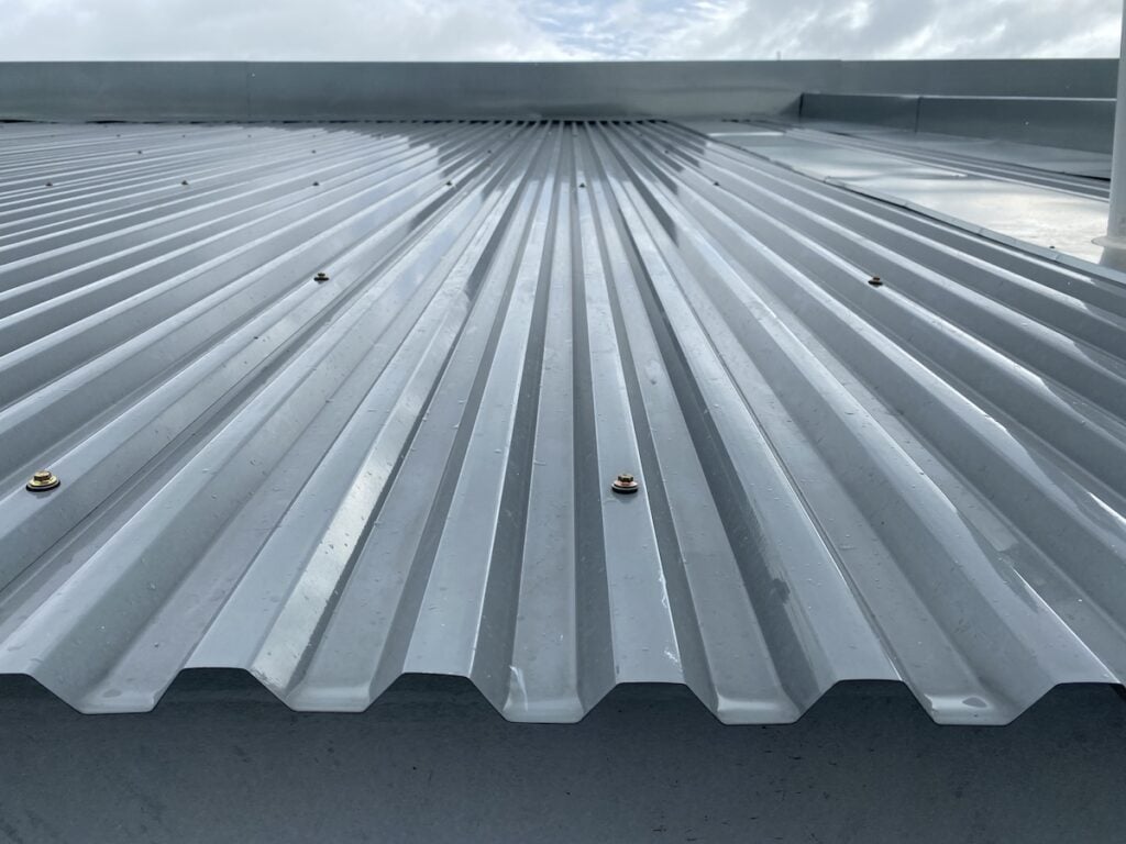 Close up of a corrugated exposed fastener metal deck roof system just installed on a building