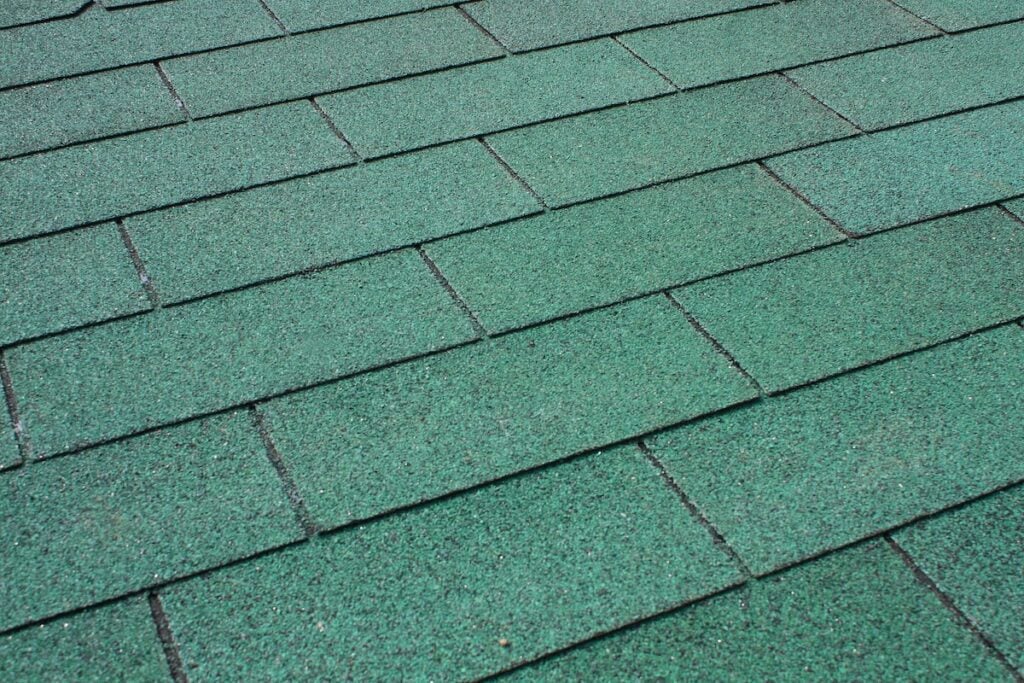 Green asphalt shingle in the shape of a rectangle on the roof