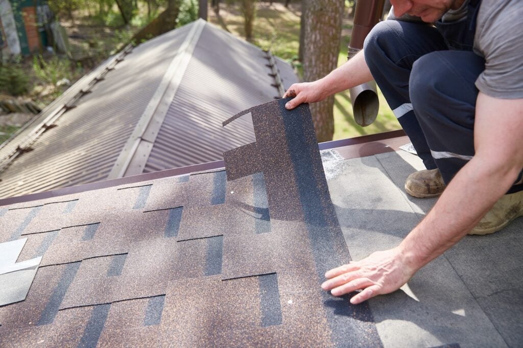 A close-up of the master's hands on the roof mounts flexible tiles