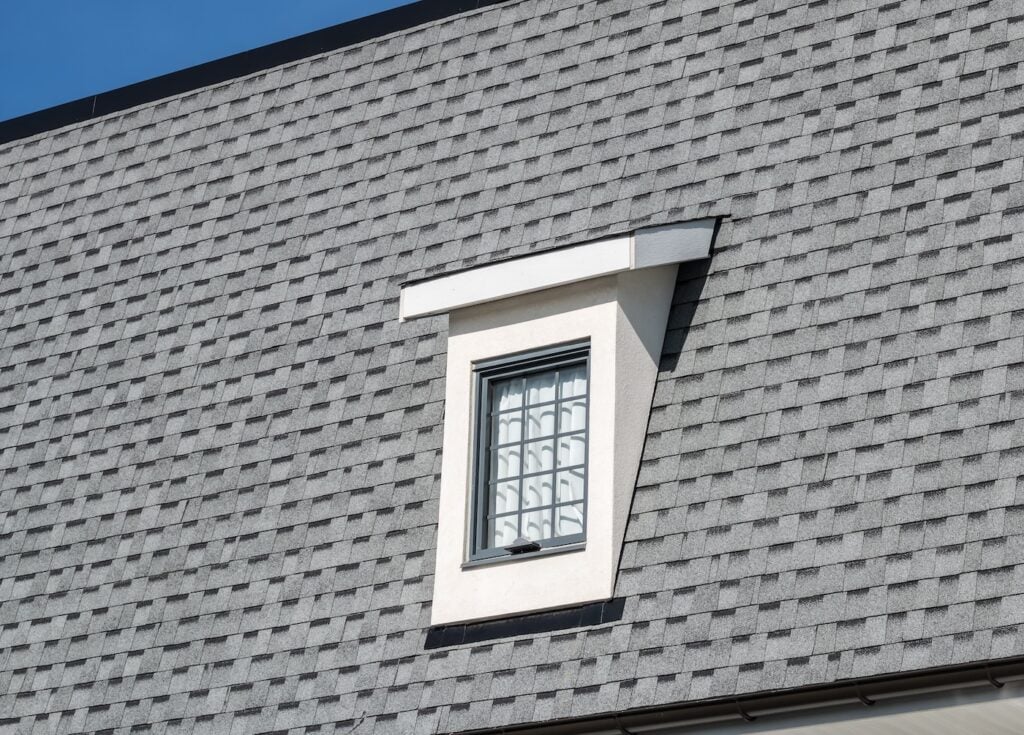 Dormer window on new house, with bright blue sky in background