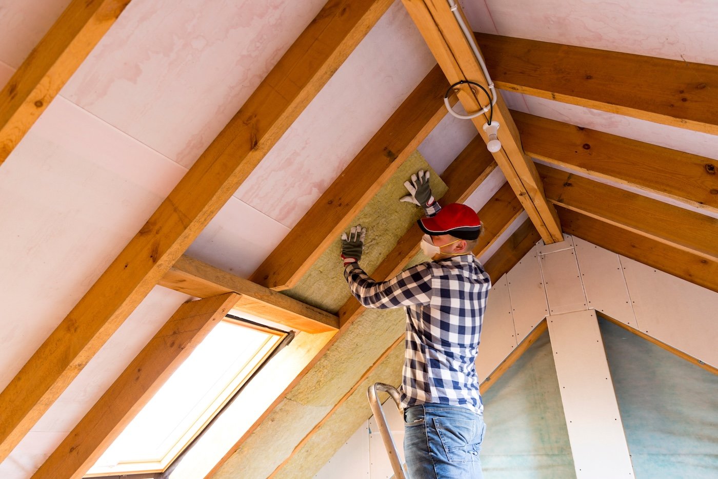 roofer installing insulation on metal seam roof