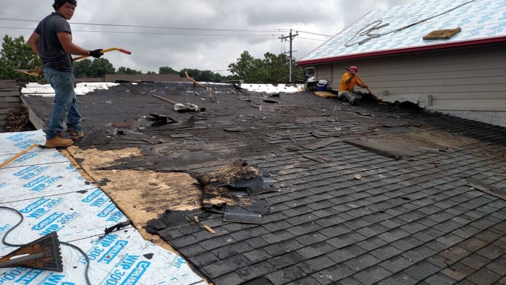 shingle roof repair CTA Exteriors workers removing shingles using shovel