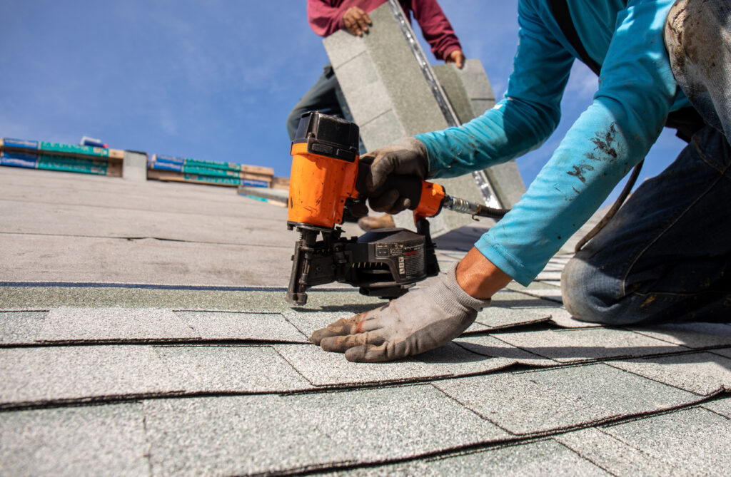 roofer installing roof shingles with pnuematic roofing nailer. lincoln university roofing contractors