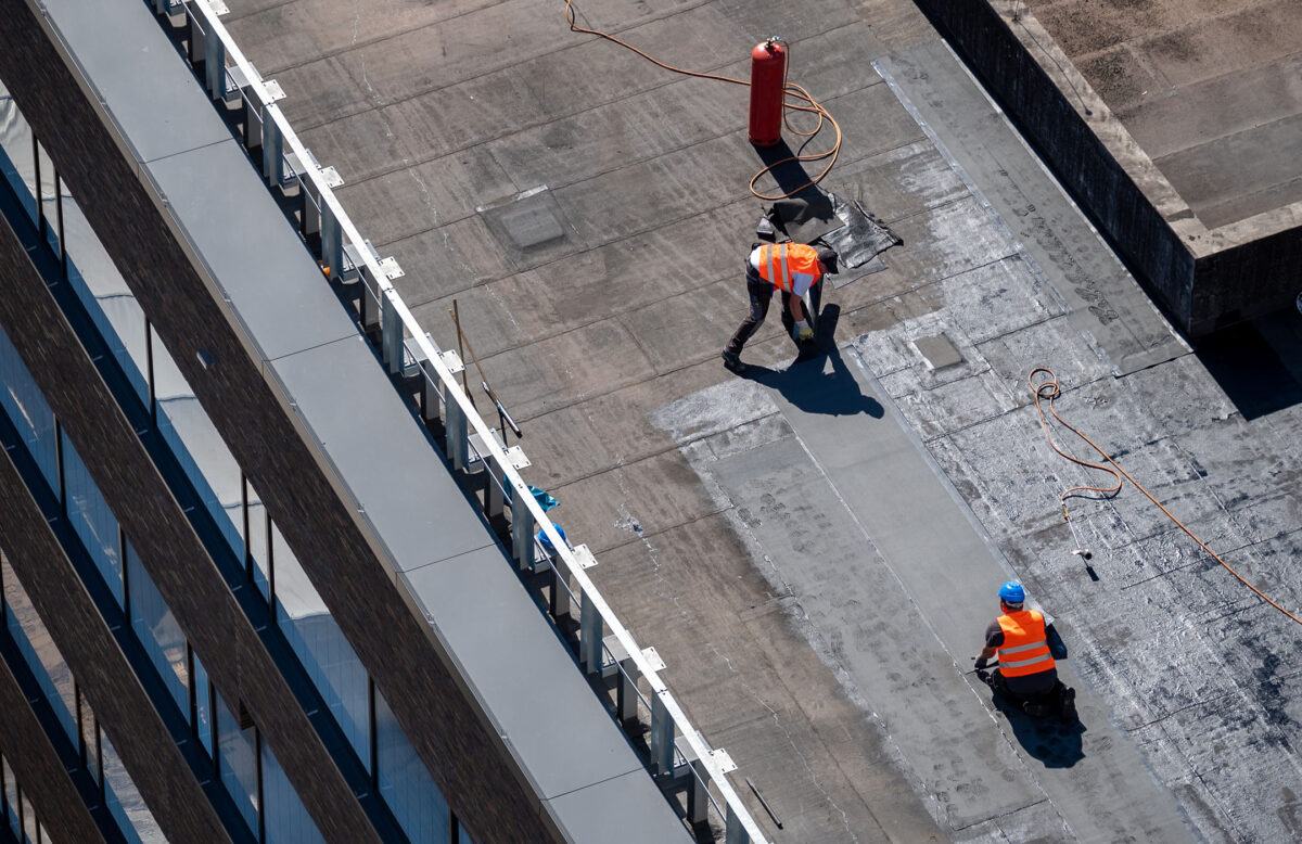 commercial roofing wilmington de Birds eye view of a roof construction site. Professional bitumen waterproofing on a flat building.