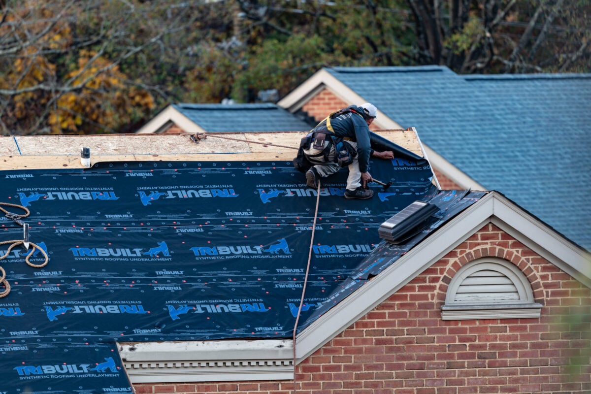 workers replacing shingles roof
