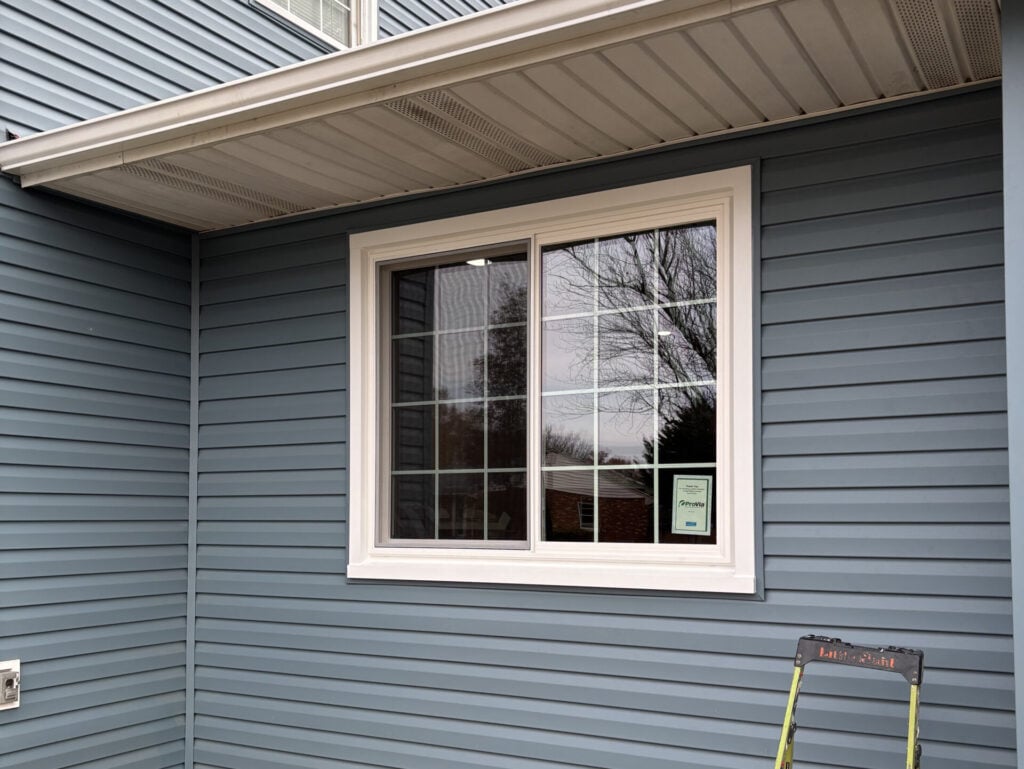window replacement cost window white frame and dark grey siding